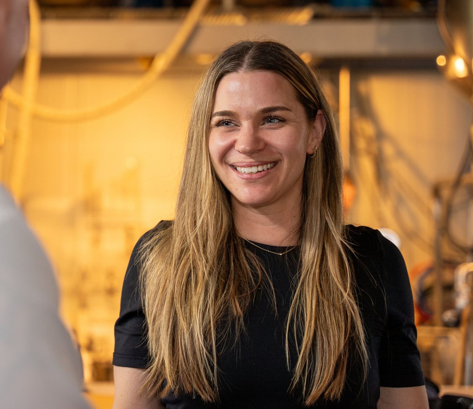 Mylène Chevrier smiling in conversation at a workplace